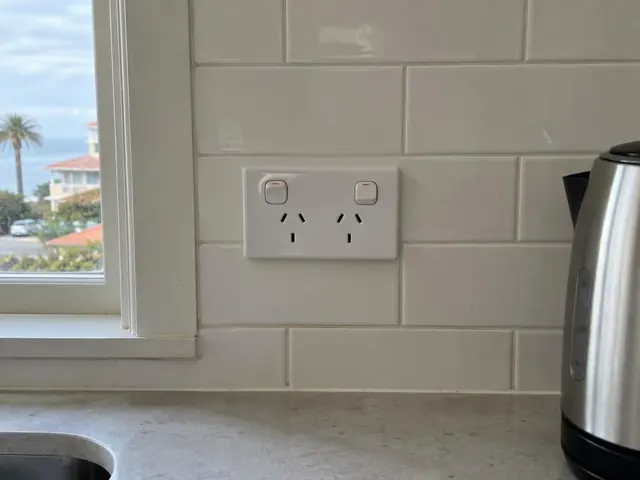 White double power point on tiled kitchen splashback beside a window and kettle in Coogee